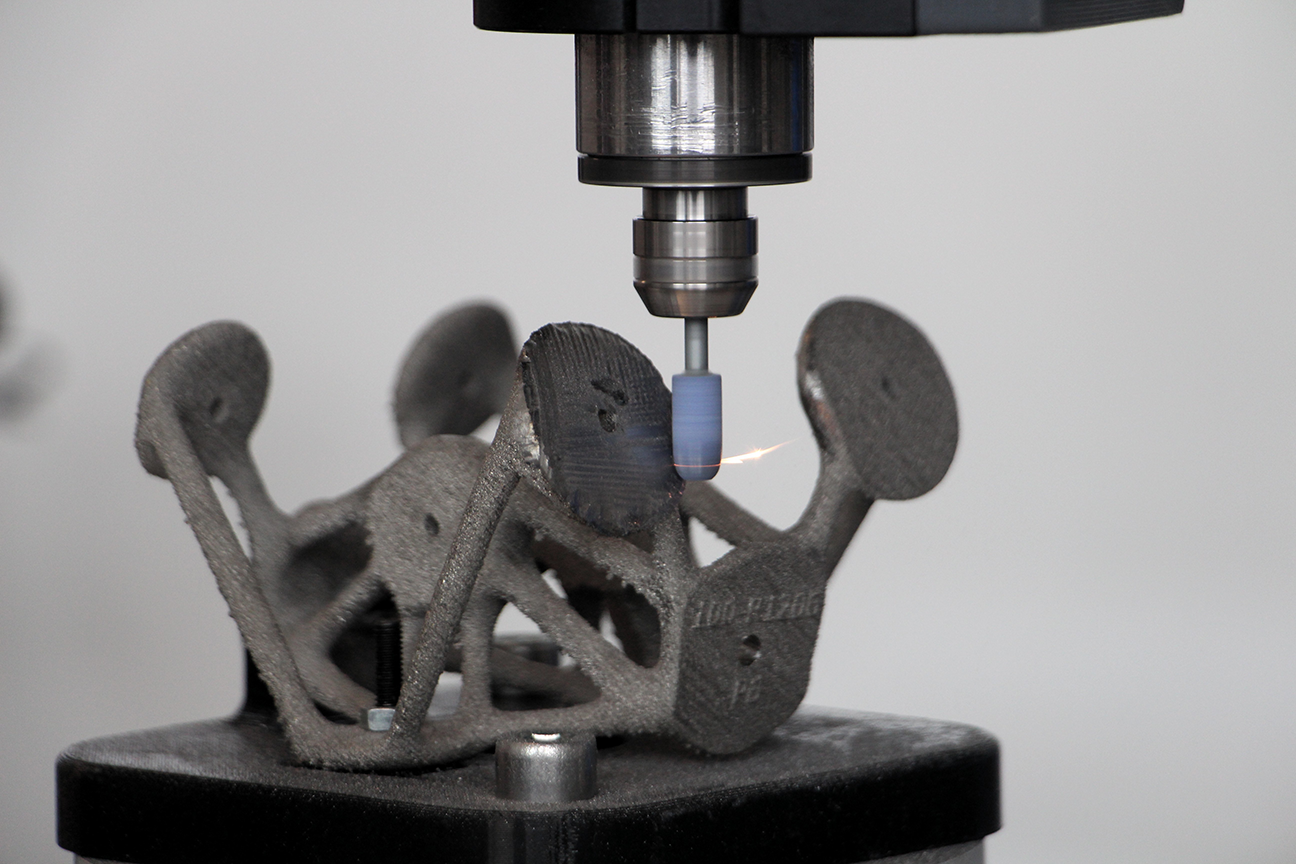 Robotic grinding using a high-speed rotary tool on an additive manufactured support for Airbus aerodynamic control surfaces.